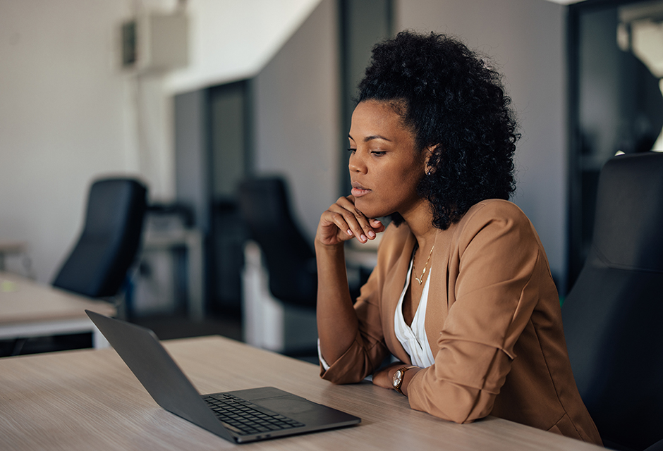 Tax professional reviewing an S corporation reasonable compensation analysis on a laptop.