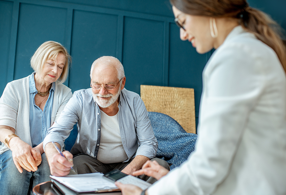 Tax professional reviews LLC ownership change paperwork with older business owners navigating a multi-member LLC to single-member LLC transition