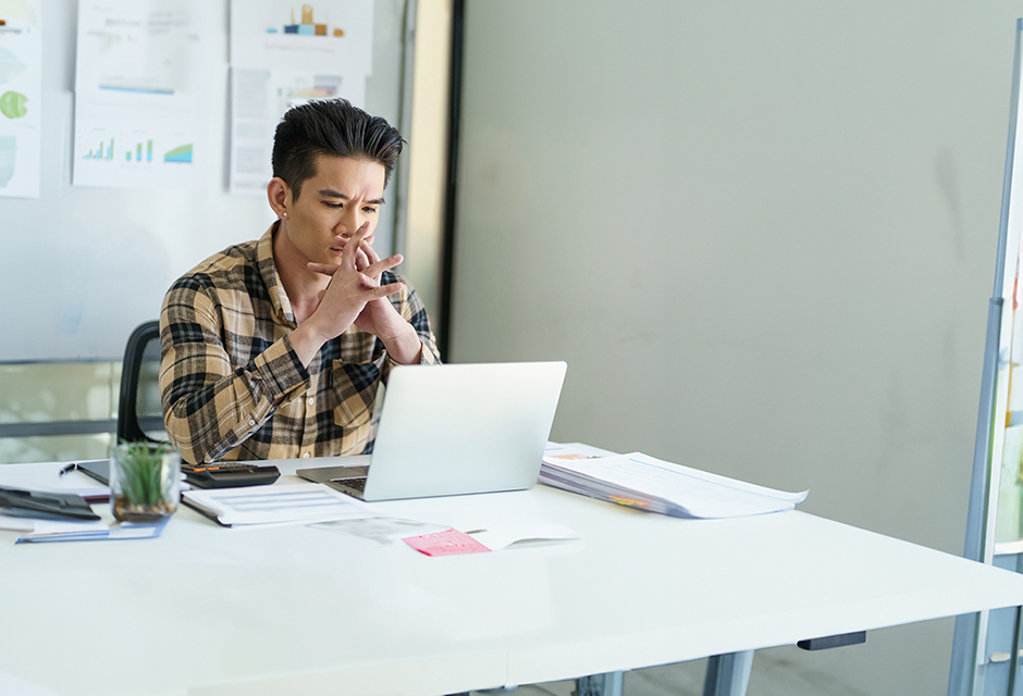 Tax professional reviewing net operating loss records on a laptop while considering a complex carryforward question