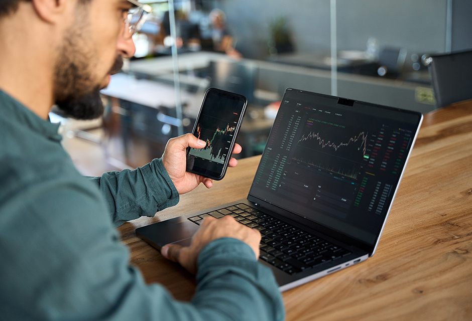 Tax professional reviewing mobile trading activity and market data for prediction market contract tax reporting