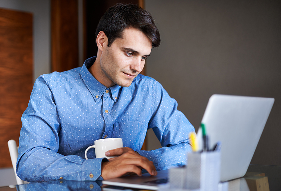 Focused tax professional reviewing 2026 client tax decisions on a laptop with a coffee mug in hand.