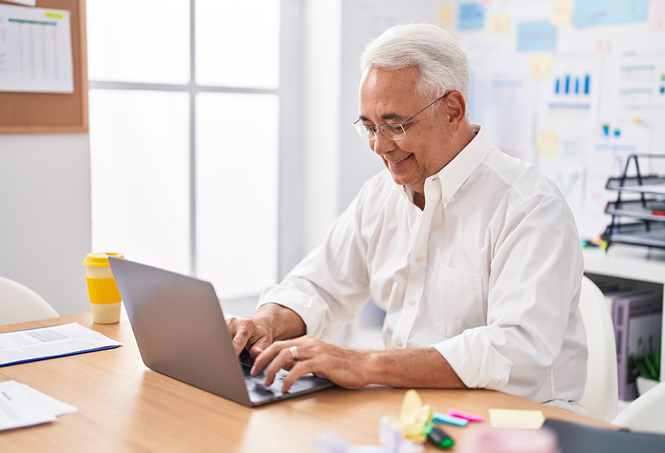 Tax professional reviewing updated BOI reporting requirements on a laptop with business documents nearby