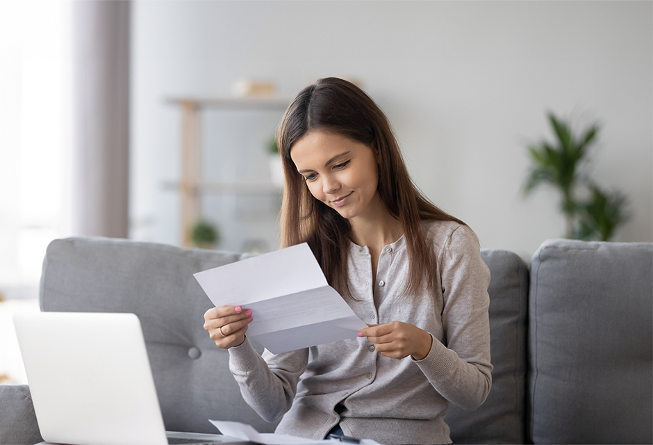 Woman reviewing an IRS notice about Automatic Exemption from Penalty relief while seated beside her laptop