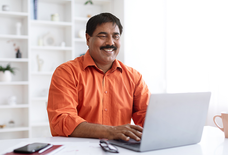 Smiling tax professional in an orange shirt working on a laptop, representing Schedule A itemized deduction planning.