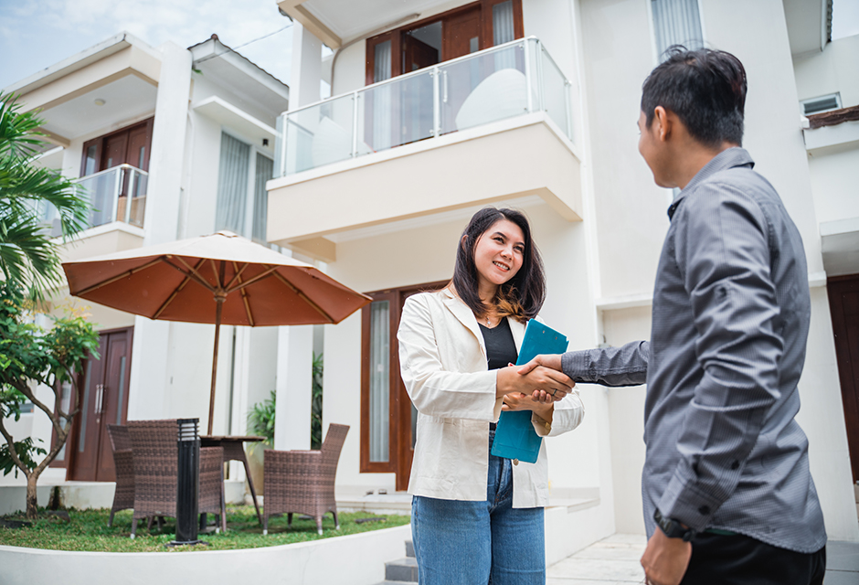 Tax professional discussing REIT investment tax treatment with client outside residential real estate property
