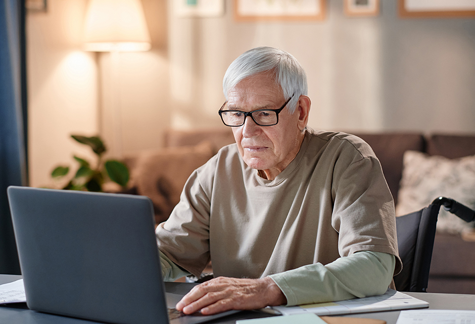 Retired minister reviewing pension and housing allowance records on a laptop at home