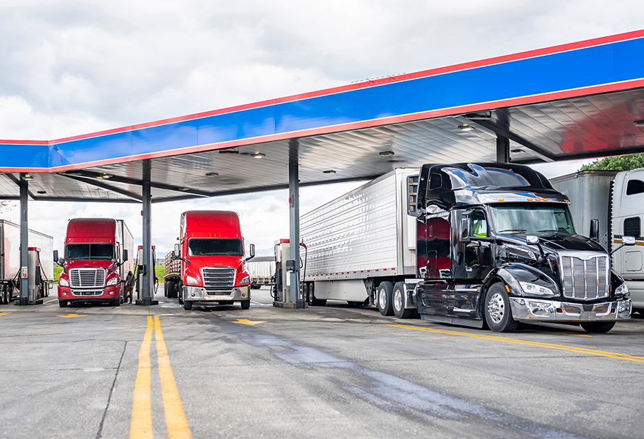 Semi trucks at a fuel station showing federal excise tax compliance for business clients
