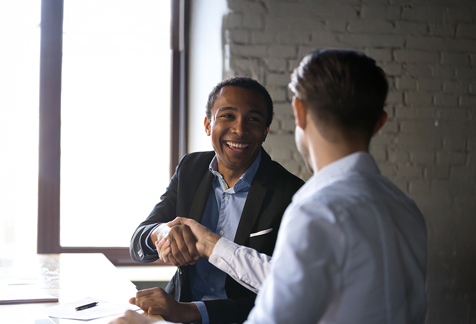 Two professionals shake hands after reaching an agreement, reflecting the Rapid Appeals Process and resolution of an IRS tax dispute.