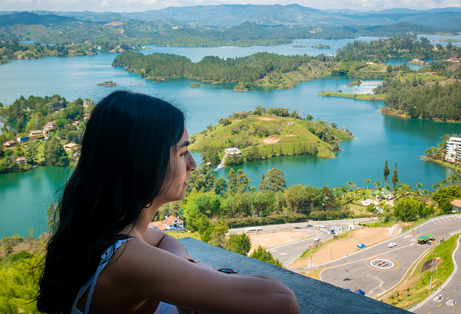 This image depicts a globally mobile individual looking out over a lush foreign landscape, representing the "tax home" and regular place of abode required to qualify for the Closer Connection Exception. 