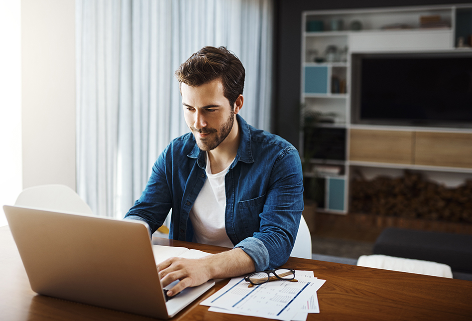A focused tax professional reviews NIIT calculations at a desk with a laptop and financial paperwork.