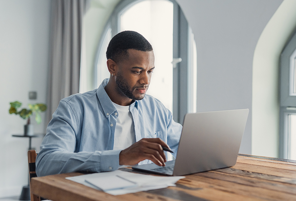 Tax professional at a laptop reviewing C corporation liquidation tax and reporting requirements.