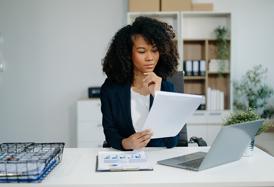 Tax professional reviewing an IRS CP53E notice with laptop to help clients verify refund and direct deposit information