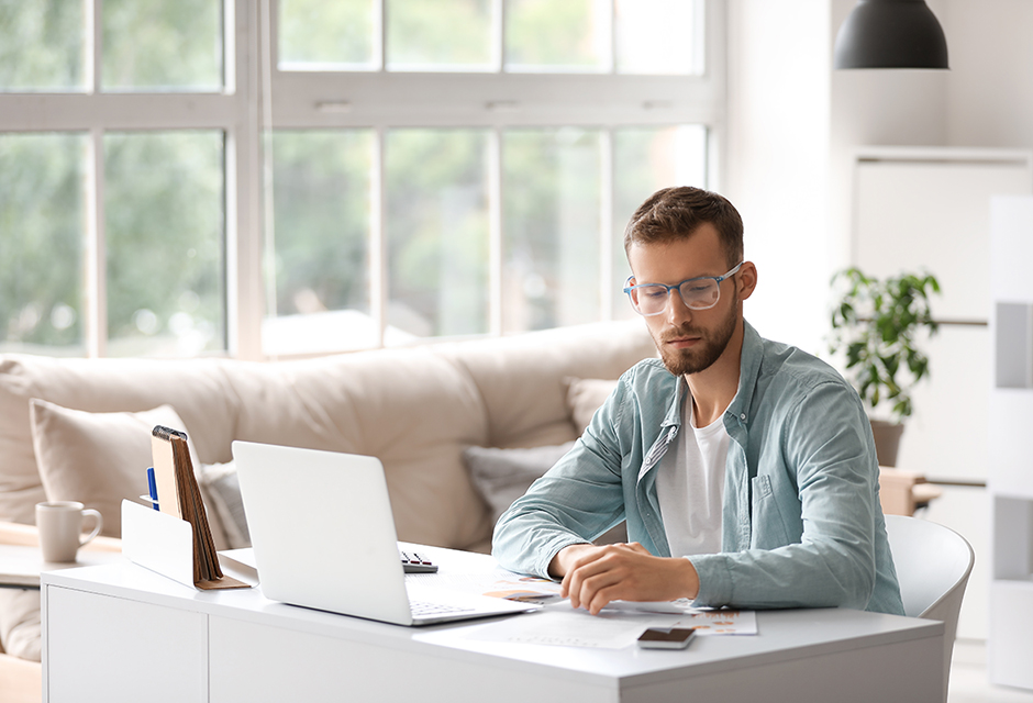 Man reviewing Form 8594 business sale documents and asset allocation figures at a home office desk.