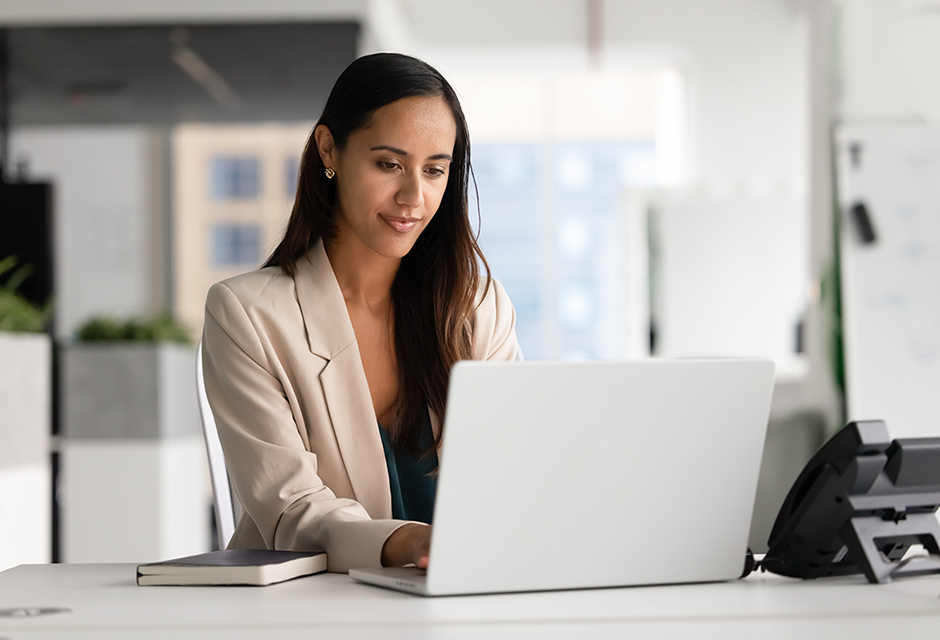 Tax professional reviewing bond interest and OID reporting rules on a laptop in an office