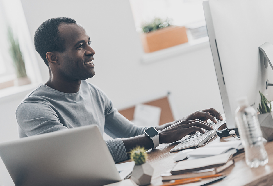 Small-business owner reviewing payment records at his computer while preparing for the updated Form 1099 reporting threshold