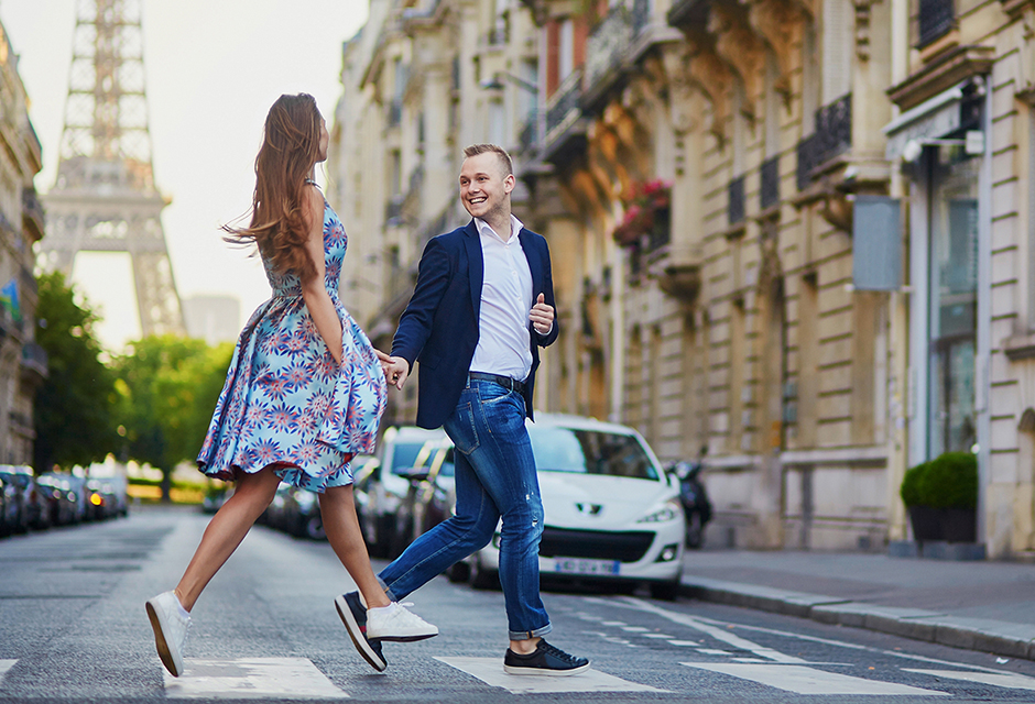 Man and woman crossing a Paris street near the Eiffel Tower, reflecting international mobility and dual-status tax residency issues.