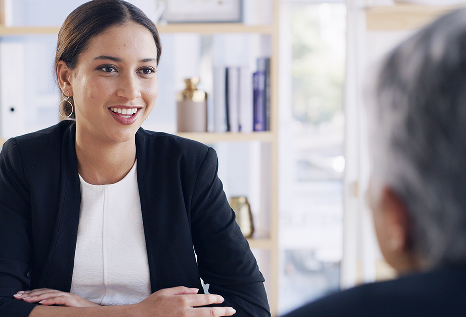 Smiling professional speaks with a client across a desk, illustrating discussions about tax filing requirements even when no tax is due.