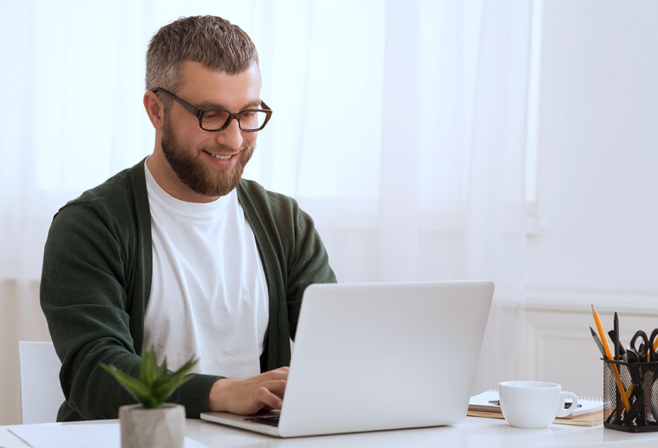 Man working on a laptop, reflecting the online filing process for correcting a missed Trump Account pilot program election.