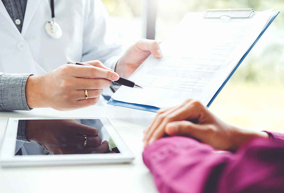 Two people review paperwork and a tablet at a desk, reflecting 2026 HSA eligibility and contribution questions.