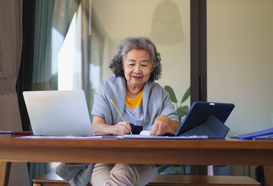 Older woman reviewing financial information on a laptop for foreign gift and inheritance reporting