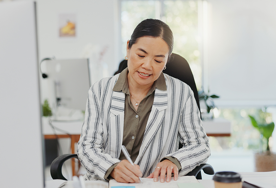 A payroll professional reviews employee records at a desk, illustrating careful Social Security number checks that help prevent W-2 errors.
