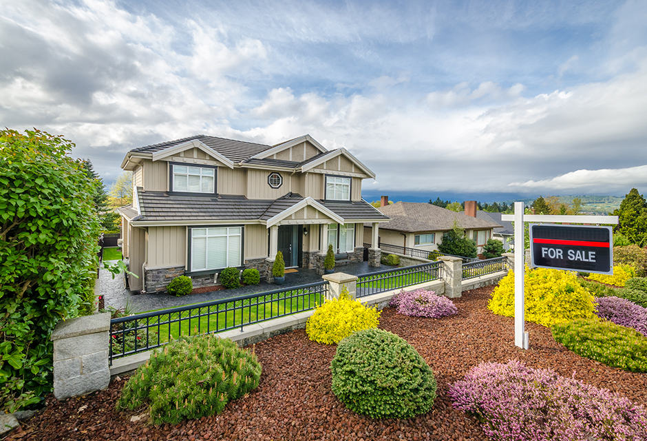 Two-story home with a for-sale sign illustrating Section 121 home sale exclusion questions for tax professionals