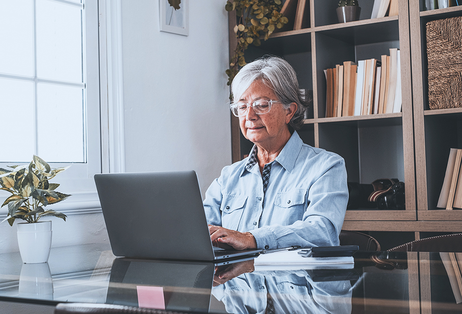 Older woman reviewing DSUE portability and Form 706 estate tax documents on a laptop after her spouse’s death