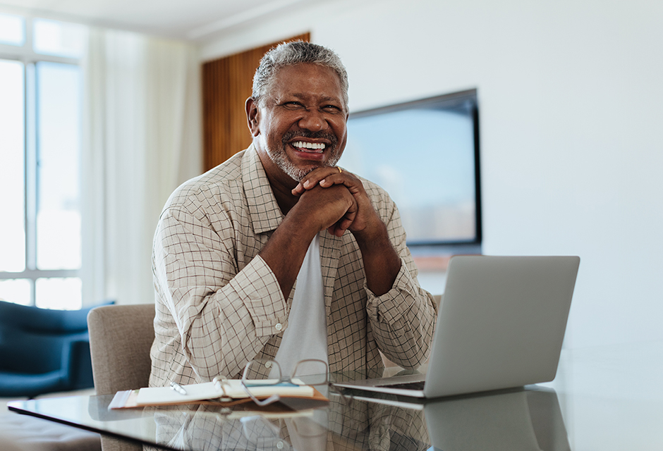 Smiling tax professional at a laptop preparing for 2027 filing-season training.