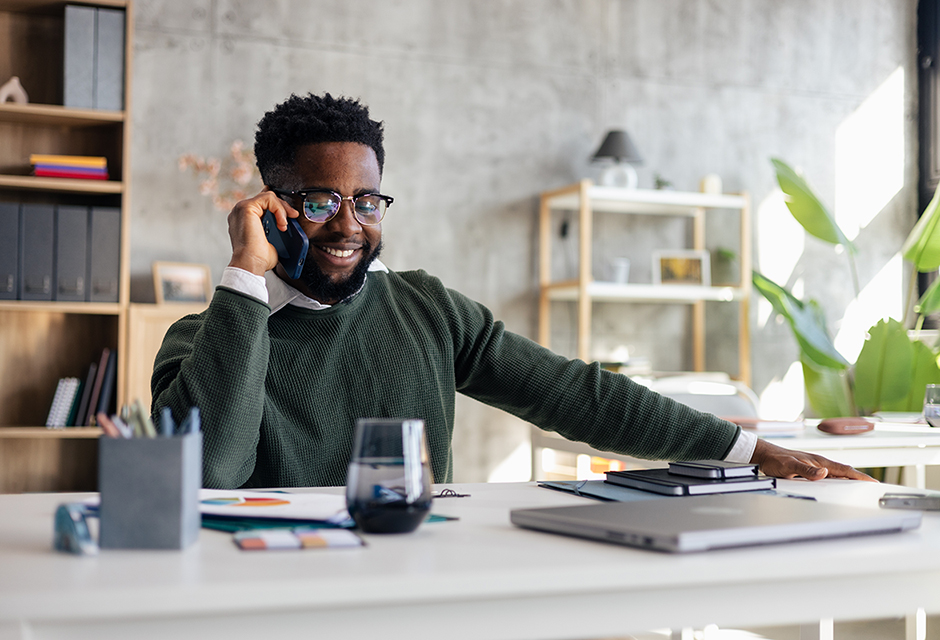 Business professional on a phone call at a desk, reflecting the records and planning involved in substantiating a QSBS exclusion.