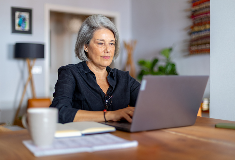 Gray-haired woman working on a laptop, reflecting client planning around durable powers of attorney and future IRS tax matters.
