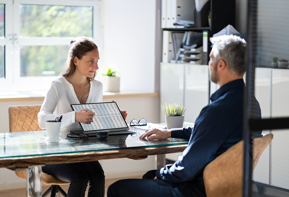 Tax professional reviews guaranteed payments and fringe benefits with a partner during a partnership tax planning meeting