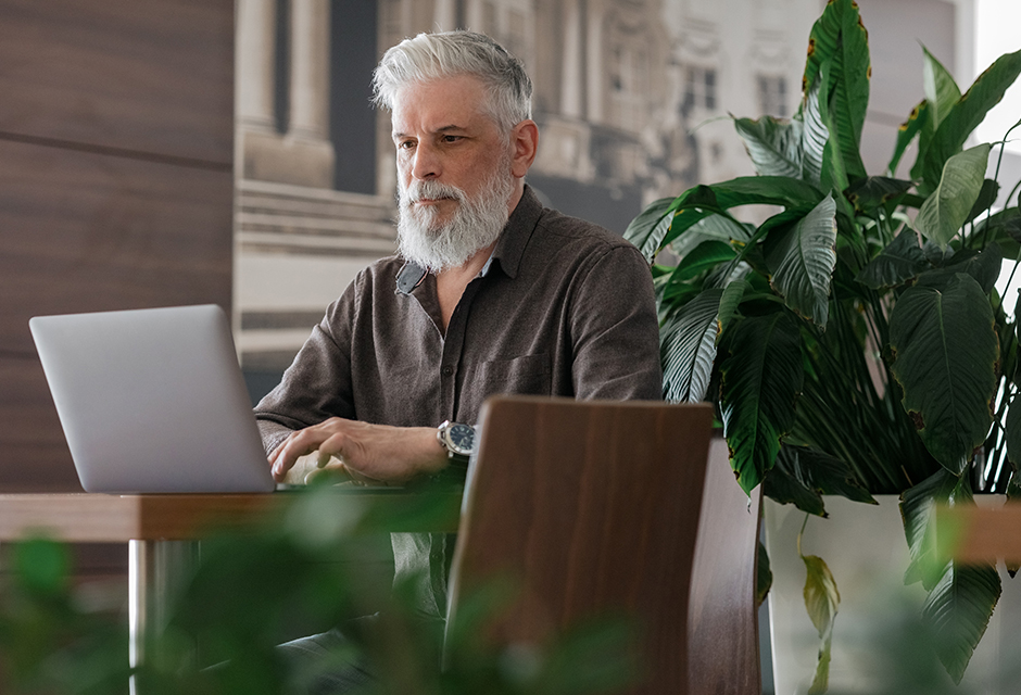 Man accessing the IRS’s new online Tax Compliance Report from his laptop
