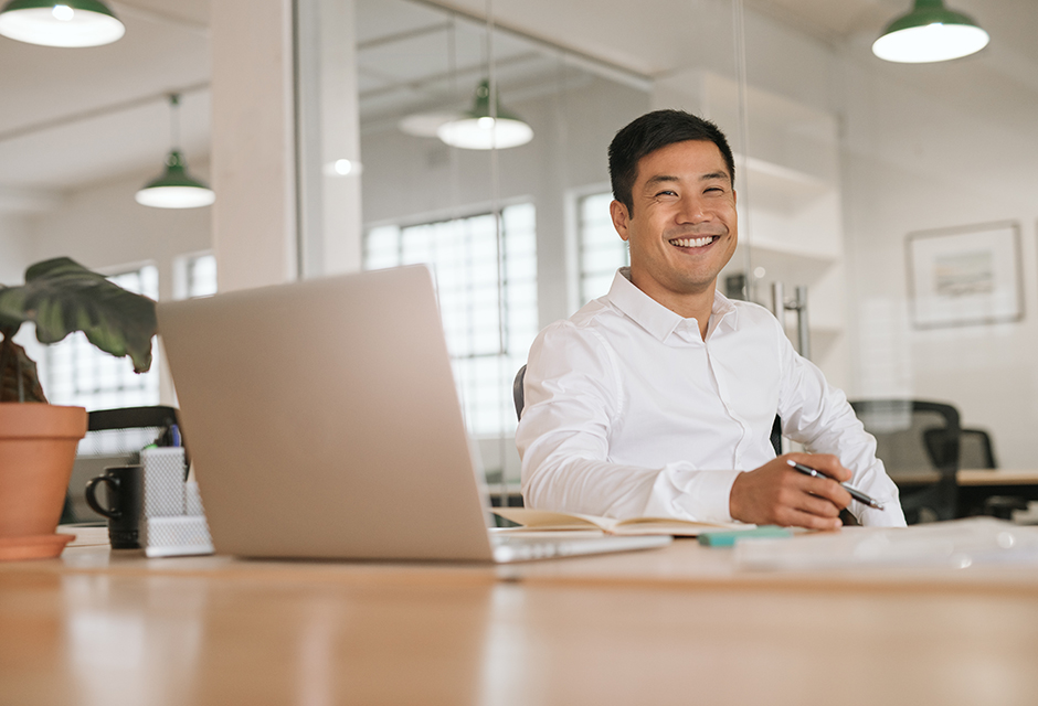 Tax professional seated at an office desk with a laptop and notebook, supporting a blog about value pricing and tax firm billing.