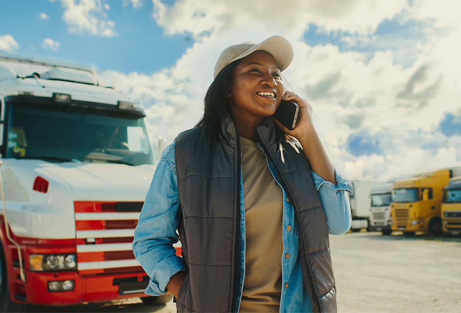 Heavy trucks lined up on a highway with a tax professional reviewing Form 2290 documents, symbolizing heavy highway vehicle use tax compliance.