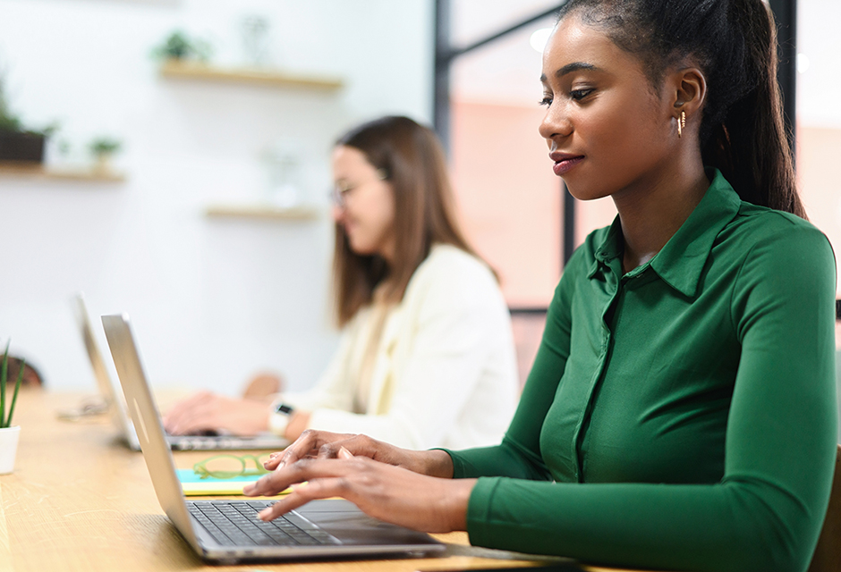 Tax professionals reviewing compliance and financial data on laptops in a modern office setting